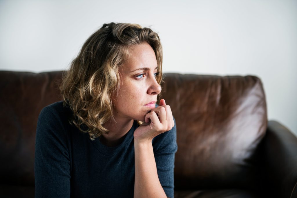 woman with depression sitting alone on her couch