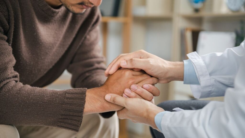 A man coping with PTSD receiving supportive care from a family member. 