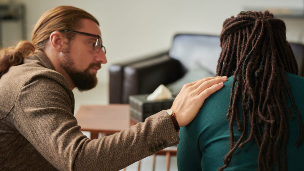 A therapist supporting a woman dealing with emotional trauma.